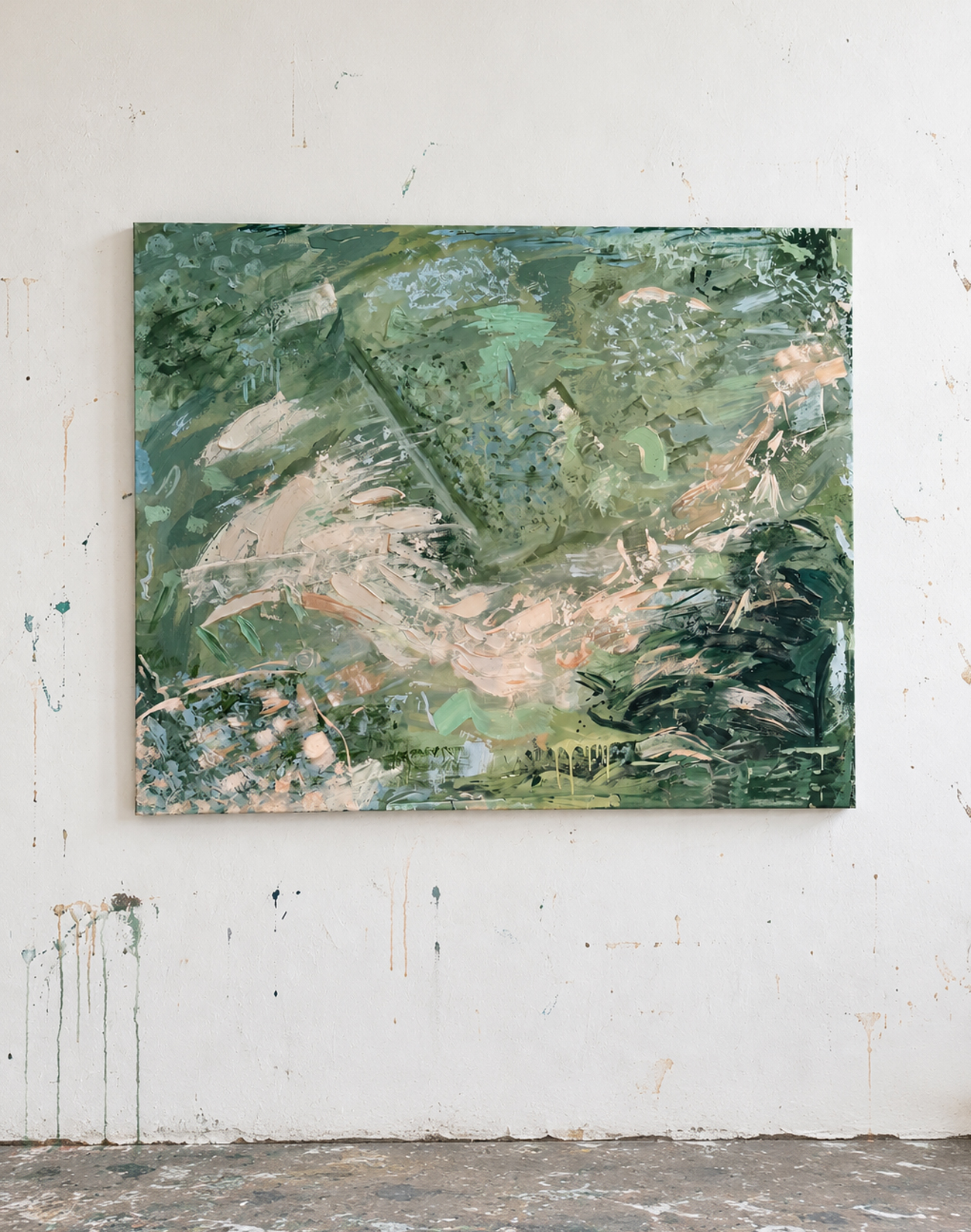 A large green abstract painting on a paint-splattered studio wall