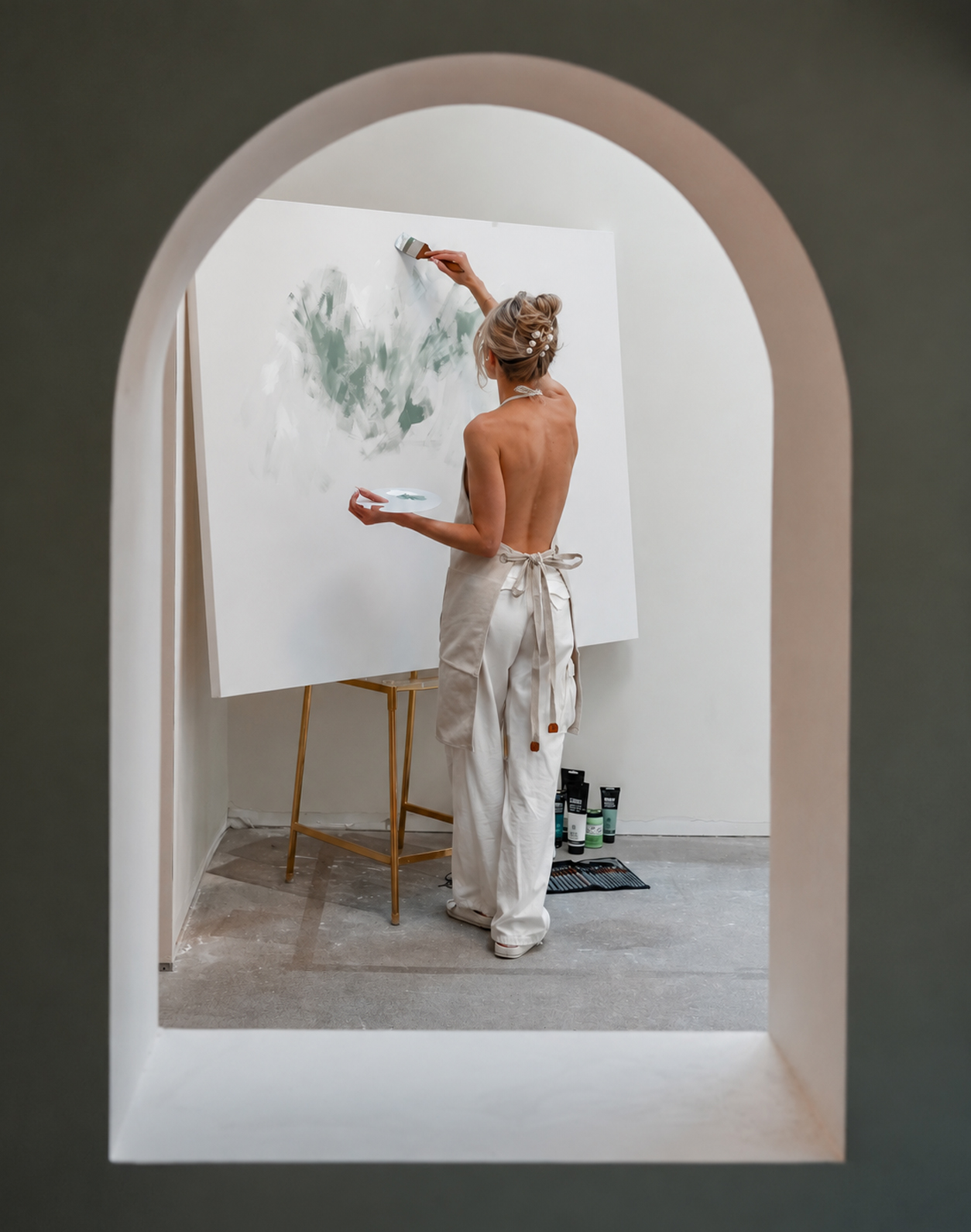 The artist painting, framed by a tall archway